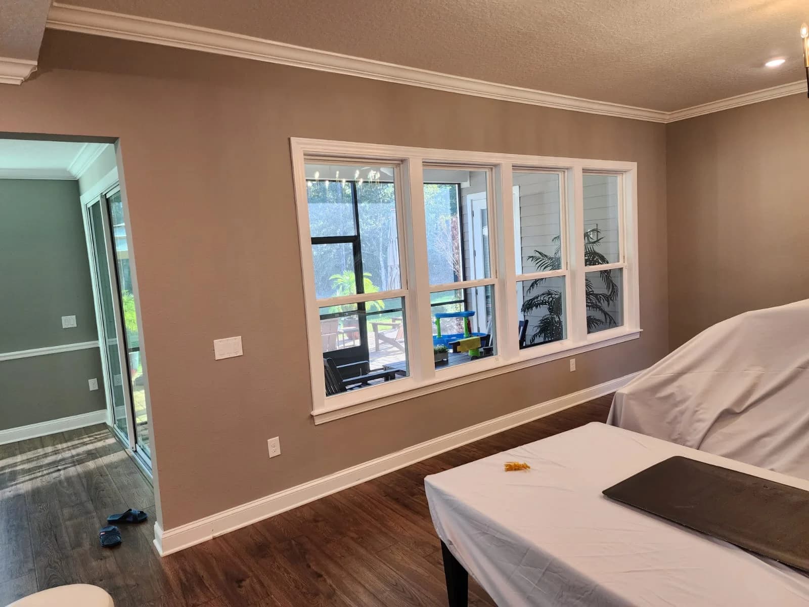 Living room interior painted in warm tan, natural light through large windows