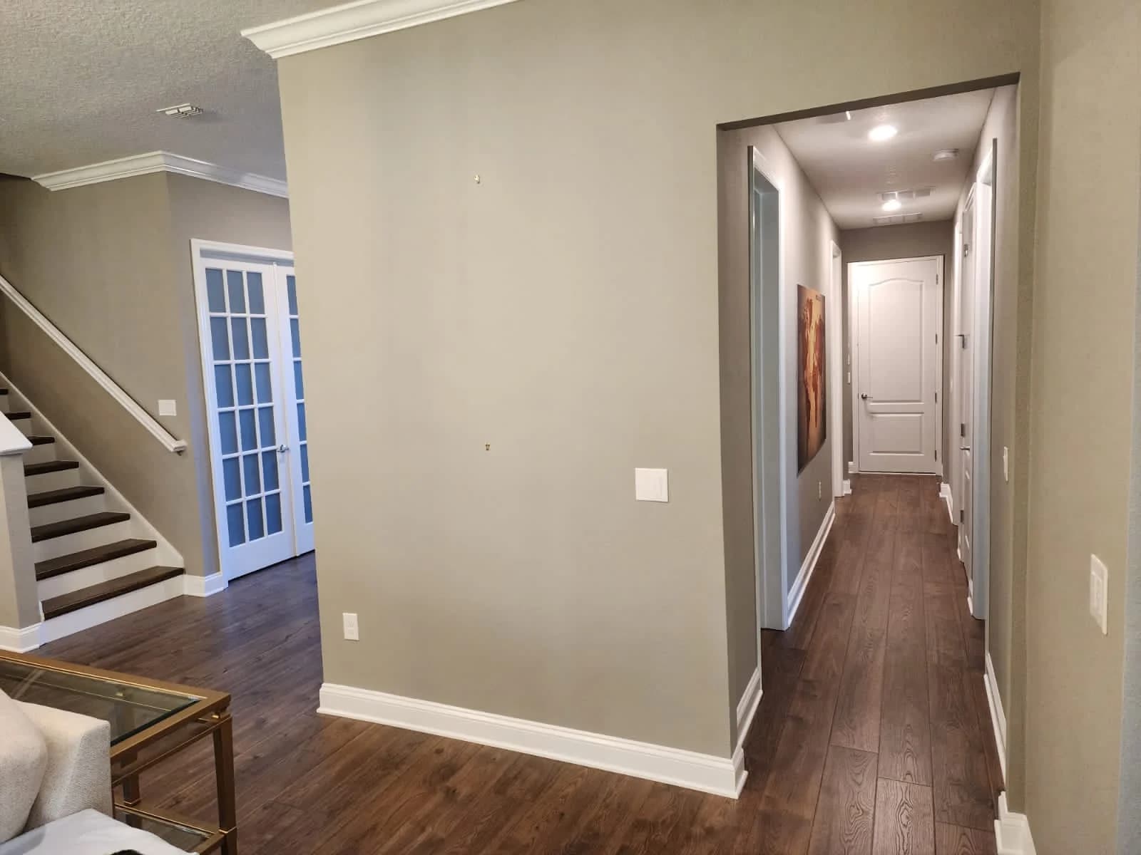 Freshly painted interior hallway with staircase in sage green, representing the same careful prep and finish quality Hardie board siding needs outside